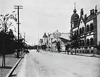 德租时期1910年代初的中山路，中央为南墙写有伊尔蒂斯泉与罗斯洋行书店广告的奥古斯特·迈尔商业楼，其左侧为水师饭店，右侧为瓦格纳时装店与中山路17号近代建筑