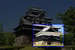 Small tower attached to a castle with dark walls, dark roofs on a platform of unhewn stones.