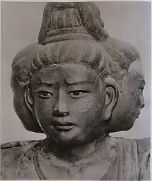 Portrait of a sculpture with three faces pointing to the front and both sides.