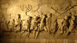 Relief carving depicting line of men carrying a menorah and other artifacts