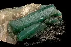 Translucent green emerald crystals in a cream-colored matrix.