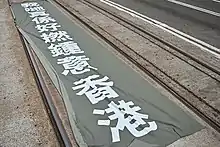 有人在灣仔北海中心對開電車路上攤開一大型直幡，寫著「我哋真係好撚鍾意香港」