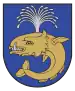 A coat of arms depicting a sea creature with sharp teeth, one protruding bottom tooth, and a blowhole spewing water