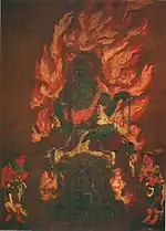 A deity with blue skin color seated on a pedestal and surrounded by flames. Two smaller figures are standing in the lower left and right corners.