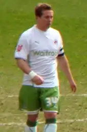 Young man with short brown hair wearing sports kit