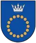 A coat of arms depicting a circle for which the boundary is itself made up of beige circles all under a silver crown on a blue background