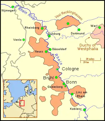 The territory is divided into nine sections; the main section borders the west bank of a wide river, and includes several important cities; other territories to the south and on the east bank of the river, are considerably smaller, and a crescent of territory south of Linz. Further north is a small section, still on the river, but separated from the main part of the territory. East of this section is "Vest Recklinghausen", and east of that is the Duchy of Westphalia. Nearby cities are, to the west, Nijmegen and Venlo, and to the east, Duisburg, Düsseldorf, and Dortmund. A big dot marks the location of Cologne, but it is distinguished from the territory by a border.