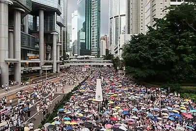 金鐘道傍晚一度下雨，遊行人士舉起雨傘，猶如2014年的「雨傘運動」