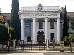 White building with the inscription Navy school of mechanics in Spanish