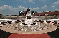 Circular plaza with sculpture of a cross in the center and plaques on the outside