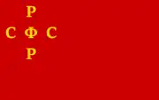 1918年7月10日批准的俄罗斯苏维埃联邦社会主义共和国国旗的早期变体（比例为1:2，旗面上的俄文縮寫為）