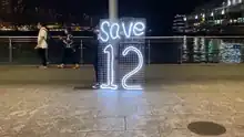 有人在海港城入口擺放「Save12」燈牌