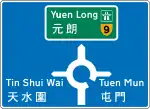 設於迴旋處前的預告方向標誌，顯示出口安排。通往快速公路的目的地以綠底表示，而區內目的地則為白底。