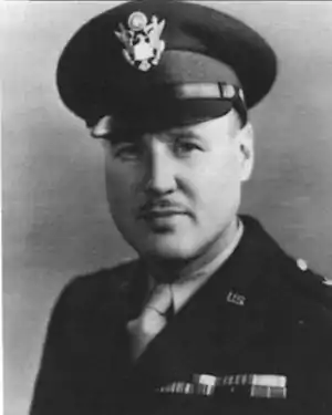 Head and shoulders of man in uniform with peaked cap and thin moustache.