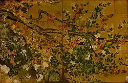 Part of a tree with leaves, red blossoms and white blossoms.