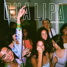 A picture of a group of women partying in a white room, with the name of the singer and the title of the song superimposed over them in capital letters.