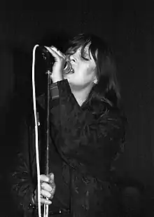 Nico singing into a microphone onstage