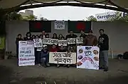 Bangladeshis of all ages holding signs in a Park in Taiwan