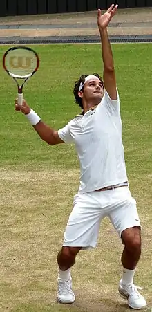 A tennis player holds a racket in his hand