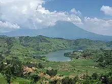 圖中湖泊後方即為維龍加山脈，照片中的山麓局部被雲層所環繞。