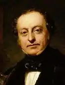 Head and shoulders painting of Sir Charles Barry. Barry is wearing a black jacket, white shirt with high collar and a soft black stock and is looking directly at the painter.