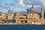 Skyline of a city with a church dome and bell tower.