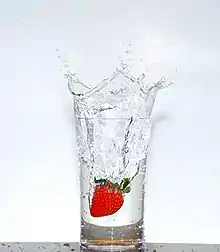 a glass of transparent water sitting on a wooden table