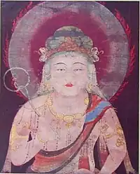 Frontal view of the upper half of a deity embellished with ornaments.