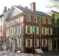 Red brick house with many windows at the corner of a block