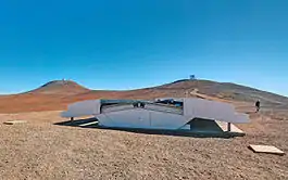 NGTS 的設備，背景左方是甚大望远镜，右方是可見光和紅外巡天望遠鏡。