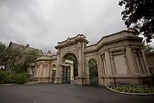 Arched gate with a lodge to right and left