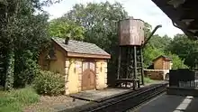 A water tower adjacent to railroad track