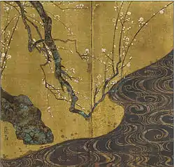 A tree branch with white blossoms and a river.